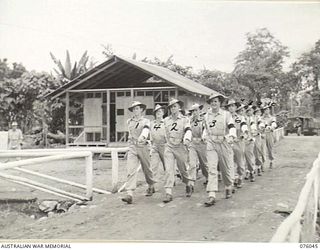 LAE, NEW GUINEA. 1944-09-21. MEMBERS OF THE NEW GUINEA FORCE PROVOST COMPANY MARCHING OFF THE UNIT PARADE GROUND. IDENTIFIED PERSONNEL ARE:- CORPORAL R.F. CONQUIT (1); CORPORAL A.A. MCDOUGALL (2); ..