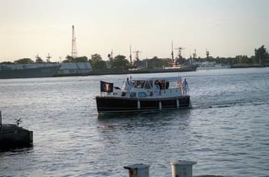 The barge of ADM Charles R. Larson, commander in chief, U.S. Pacific Command, transports President George Bush and Mrs. Bush as it approaches the USS ARIZONA MEMORIAL during an observance commemorating the 50th anniversary of the Japanese attack on Pearl Harbor