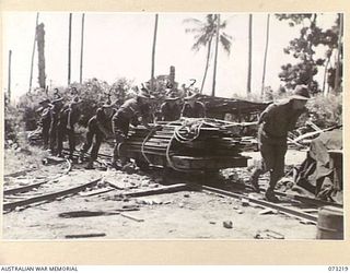 ALEXISHAFEN, NEW GUINEA. 1944-05. MEMBERS OF THE 2/15TH FIELD AMBULANCE MAKING USE OF THE TROLLEYS AND LINES WHICH WERE LAID AT THE OLD CATHOLIC MISSION FOR THE TRANSPORTATION OF COPRA AND SUPPLIES ..