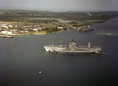 Large harbor tugs maneuver the amphibious command ship USS BLUE RIDGE (LCC 19) into the harbor