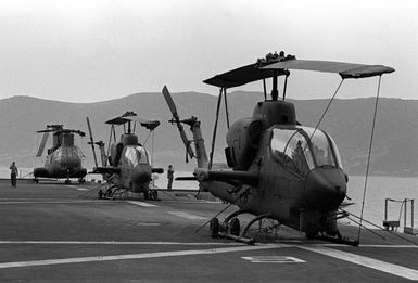 Two AH-1 Sea Cobra and a CH-46 Sea Knight helicopter are secured on the deck of the amphibious ship USS SAIPAN (LHA-2) during NATO exercise Display Determination '81