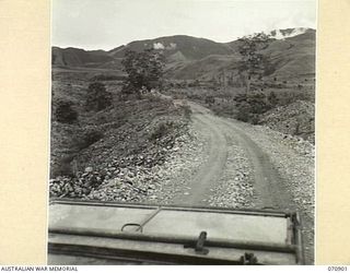 Wau Lae Road, New Guinea. 1944-02-26. A point on the road twenty eight miles from Wau showing a good surface resulting from the use of gold dredge tailings. This area of road was maintained by the ..