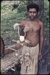 Kula ring: man displays white shell armband (mwali)