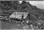 Woman and menstrual hut, with Sinalagu habour below