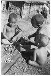 Three children eating ngari nuts, cannarium almonds