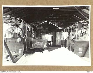 17 MILE, PORT MORESBY AREA, NEW GUINEA. 1943-12-04. INTERIOR VIEW OF THE 9TH AUSTRALIAN DIVISION MOBILE LAUNDRY. THIS UNIT OPERATES 24 HOURS PER DAY AND HANDLES APPROXIMATELY 8000 ARTICLES EACH ..