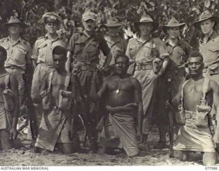 WUNUNG PLANTATION, NEW BRITAIN. 1944-12-30. PERSONNEL OF THE ALLIED INTELLIGENCE BUREAU, HEADQUARTERS, 5TH DIVISION WITH THEIR NATIVE ESCORT ON THE BEACH. BACK ROW, LEFT TO RIGHT: 276393 FLIGHT ..