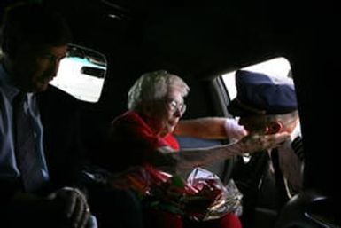 Eleanor Keller, cq, center, thanks United Captain Hans Miesler as he presents her with flowers from Hawaii after flying the remains of her brother, Robert Keller, back to Denver International Airport on Tuesday, June 20, 2006. More than 60 years ago, WW