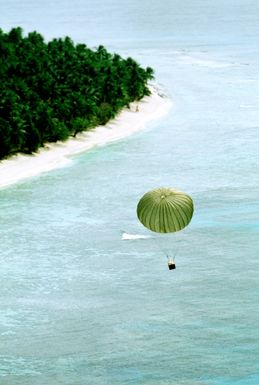 A container floats toward its island destination after being airdropped from a 374th Tactical Airlift Wing C-130 Hercules aircraft during Christmas Drop container floats toward its destination. The annual airdrop is a humanitarian effort providing aid to needy islanders throughout Micronesia during the holiday season