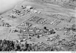 LAE, NEW GUINEA. AERIAL VIEW PRIOR TO THE JAPANESE OCCUPATION. AT THE TOP OF THE PHOTOGRAPH IS THE AIRSTRIP WHERE TRANSPORT AIRCRAFT USED TO SUPPLY THE GOLDFIELDS ARE PARKED. (NAVAL HISTORICAL ..