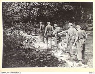BOUGAINVILLE, 1945-05-31. A FIGHTING RECONNAISSANCE PATROL OF A COMPANY, 47 INFANTRY BATTALION, UNDER THE COMMAND OF LIEUTENANT J.M. WOODHEAD (1), CROSSING THE BONARA RIVER TO INVESTIGATE A NATIVE ..