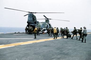 Marines of the 22nd Marine Expeditionary Unit (22nd MEU) file aboard a Marine Medium Helicopter Squadron 261 (HMM-261) CH-46E Sea Knight helicopter on the flight deck of the amphibious assault ship USS SAIPAN (LHA-2) during a rehearsal for Operation Sharp Edge. The SAIPAN is on station off the coast of Liberia