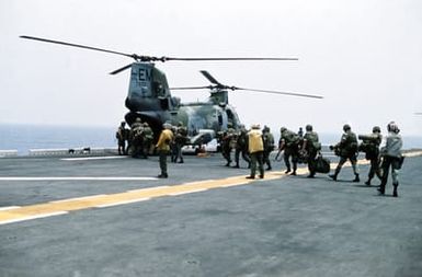 Marines of the 22nd Marine Expeditionary Unit (22nd MEU) file aboard a Marine Medium Helicopter Squadron 261 (HMM-261) CH-46E Sea Knight helicopter on the flight deck of the amphibious assault ship USS SAIPAN (LHA-2) during a rehearsal for Operation Sharp Edge. The SAIPAN is on station off the coast of Liberia