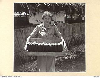 CAPE WOM, WEWAK AREA, NEW GUINEA. 1945-08-02. SUPERINTENDENT J.M. HART, RED CROSS SOCIETY REPRESENTATIVE, 104 CASUALTY CLEARING STATION, READY TO START HER ROUNDS OF THE WARDS WITH LIBRARY BOOKS