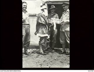 Ramu Valley, New Guinea. 1943-12-25. NX103434 Captain F. D. Smith (1) dressed as Father Christmas giving a present to General Officer Commanding, 7th Division at the 2/6th Field Ambulance Christmas ..