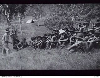 NEW GUINEA. 1943-08-20. NX8975 LIEUTENANT B. A. KITCHEN, EDUCATION OFFICER, HEADQUARTERS, 21ST AUSTRALIAN INFANTRY BRIGADE, EXPLAINING TO THE TROOPS HOW TO VOTE IN THE ELECTION FOR THE HOUSE OF ..