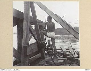 WIDE BAY, NEW BRITAIN. 1945-05-02. SAPPERS OF 13 FIELD COMPANY, ROYAL AUSTRALIAN ENGINEERS, USING A PNEUMATIC DRILL ON A PILE DRIVER WHILE CONSTRUCTING THE NEW DOCKS