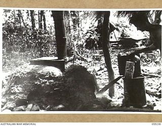 DUMPU, NEW GUINEA, 1943-10-23. A BUILT IN STOVE WITH AN OIL AND WATER DRIP BURNER IN THE OUTDOORS AT HEADQUARTERS, 7TH AUSTRALIAN DIVISION