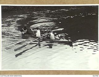 KUBA LAKE, RAMU VALLEY, NEW GUINEA. 1943-12-25. COMPETITORS IN THE BOAT RACE MOVING UP FOR THE START IN THEIR HOME-MADE CRAFT AT THE CHRISTMAS CARNIVAL AND REGATTA ORGANISED BY MEMBERS OF THE ..