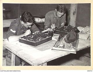 YALU, NEW GUINEA. 1945-08-03. PRIVATE G.T. SOMERVILLE (1) AND CORPORAL A. LESIRE (2), COLOURING AND ADDING TEXTURE TO A MODEL AT THE NEW GUINEA TRAINING SCHOOL