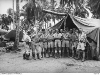 MILNE BAY, PAPUA. 1942-09. GROUP OF FIGHTER PILOTS, MAINLY OF NO. 76 SQUADRON RAAF. THE COMMANDING OFFICER OF 76 SQUADRON, SQUADRON LEADER K.W. TRUSCOTT, IS SEEN THIRD FROM THE LEFT, EVIDENTLY ..
