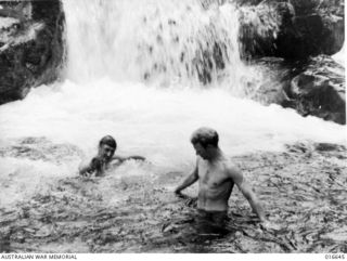 New Guinea. 1944-03. RAAF airmen enjoying a cool dip in an icy stream after returning from a bombing raid