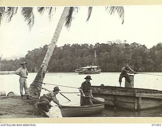 LABU POINT, LAE, NEW GUINEA. 1944-03-24. THE VIEW ADJACENT TO THE WORKSHOPS SHOWING PONTOONS AND SMALL CRAFT AWAITING REPAIR AT THE 1ST WATERCRAFT WORKSHOP. THE PEOPLE IN THE PHOTOGRAPH ARE NOT ..