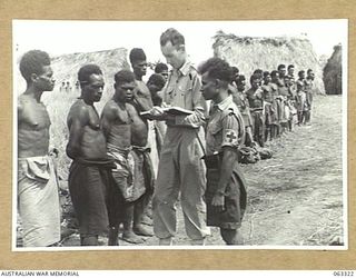 DUMPU, NEW GUINEA. 1944-01-04. NG2446 SERGEANT J. B. BRENNAN, MEDICAL ORDERLY, AUSTRALIAN AND NEW GUINEA ADMINISTRATION UNITS, (1); ATTACHED TO THE 7TH DIVISION, ASSISTED BY MAKU, A PAPUAN "DOCTOR ..