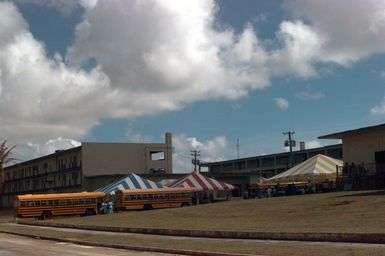 Typhoon victims are bussed in from schools used as shelters to temporary housing of converted dorms at Andersen Air Force Base south, Guam, after Super Typhoon Paka destroyed or badly damaged their homes. Here they may have a bit more privacy and better facilities as well as freeing up schools to begin classes in January