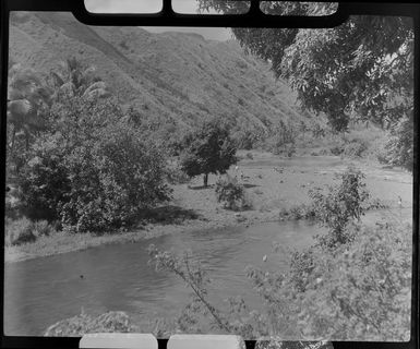 River scene, Tahiti, showing hills, trees and people in river