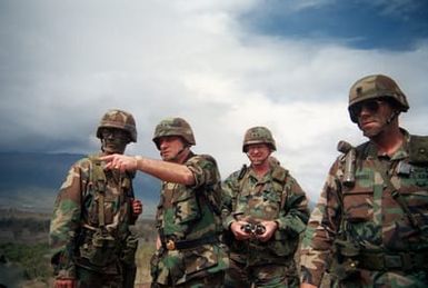 Army CHIEF of STAFF General (GEN) Carl E. Vuono, second from left, makes a point while speaking with a lieutenant from the 25th Infantry Division (Light), during a visit to the training area. Accompanying the general is Major General (MGEN) Charles P. Ots