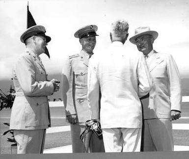 Former President Harry S. Truman visiting with an unidentified man and two unidentified Marines at the Marine Corps Air Station, Kaneohe Bay, Hawaii