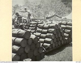 KILIGIA, NEW GUINEA, 1944-03-14. SX39832 SERGEANT J.W. INGE (1), AND VX55524 LIEUTENANT M.A. BLAND (2), OFFICER COMMANDING 8TH FIELD BAKERY PLATOON, AT THE UNIT STORES DUMP INSPECTING FLOUR AND ..