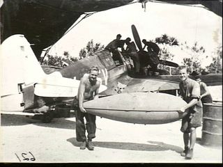 KIRIWINA, TROBRIAND ISLANDS, PAPUA. 1944-01-31. LEADING AIRCRAFTMAN (LAC) A. S. HARVEY, LEICHHARDT, NSW, AND LAC A. J. WESTON, HUNTERS HILL, NSW, CARRYING THE BELLY TANK FROM A KITTYHAWK AIRCRAFT ..