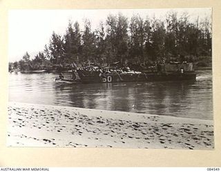 JABA RIVER AREA, BOUGAINVILLE, SOLOMON ISLANDS. 1944-12-18. A BARGE TRANSPORTING B COMPANY, 15 INFANTRY BATTALION TO THE SOUTH BANK OF THE RIVER TO ESTABLISH NEW POSITIONS