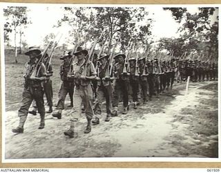 POM POM VALLEY, NEW GUINEA. 1943-11-30. 2/12TH AUSTRALIAN INFANTRY BATTALION, ADVANCING IN "COLUMN OF ROUTE" AS THEY MARCH OFF THE SPORTSGROUND. IDENTIFIED PERSONNEL ARE: SERGEANT S. WEBB (1); ..