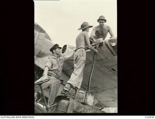 VIVIGANI, GOODENOUGH ISLAND, PAPUA. 1943-12-26. FLYING OFFICER E. ROBINSON OF TORQUAY, QLD (LEFT), AND NO. 30 (BEAUFIGHTER) SQUADRON RAAF, CHECKING THE LOADING OF AMMUNITION INTO THE WING GUNS OF ..