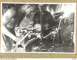 RAMU VALLEY, NEW GUINEA. 1943-12-21. VX131755 SAPPER G. N. WILCOX (1) AND VX84628 STAFF SERGEANT A. J. ADDISON (2) IN THE WORKSHOP OF THE 53RD AUSTRALIAN FIELD PARK COMPANY, ROYAL AUSTRALIAN ..