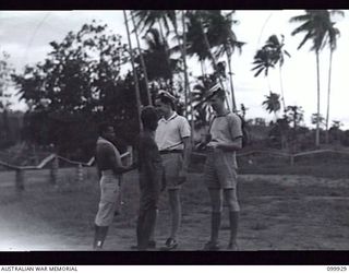 RABAUL, NEW BRITAIN, 1946-03-20. STOKER M. PINKERTON (1) AND STOKER J. SAWDY (2) MEMBERS OF THE RAN CHATTING WITH LOCAL NATIVES, DURING SHORE LEAVE IN THE AREA