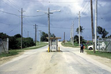 View of the back gate of U.S. Naval Activities Guam. Note the cyclone warning sign to the right