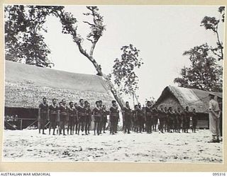 CAPE CUNNINGHAM, NEW BRITAIN, 1945-08-15. MEMBERS OF THE ROYAL PAPUAN CONSTABULARY LINED UP ON PARADE LISTENING TO MAJOR C.D. BATES, DISTRICT OFFICER, HEADQUARTERS AUSTRALIAN NEW GUINEA ..