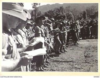 TOROKINA, BOUGAINVILLE. 1945-08-16. TROOPS SINGING A HYMN AT THE VICTORY THANKSGIVING SERVICE HELD AT GLOUCESTER OVAL FOR TROOPS OF THE AUSTRALIAN MILITARY FORCES