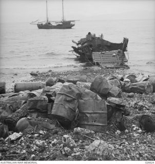 MILNE BAY, PAPUA, 1942-09. PETROL DRUMS AND AN INVASION BARGE BLASTED BY THE ROYAL AUSTRALIAN AIR FORCE WHEN THE JAPANESE ATTEMPTED TO LAND AT MILNE BAY