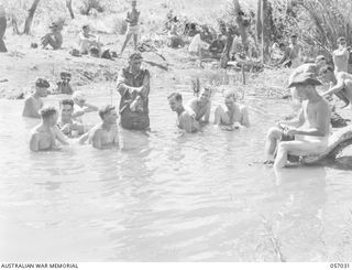 NADZAB, NEW GUINEA. 1943-09-19. PERSONNEL OF THE 2/5TH AUSTRALIAN FIELD COMPANY WASHING THEMSELVES AND THEIR CLOTHES IN A SMALL CREEK. SHOWN: VX138085 SAPPER (SPR) J. W. HATTON (1); NX20836 SPR L. ..