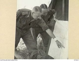 MADANG, NEW GUINEA. 1944-04-27. NX110380 BRIGADIER C.E. CAMERON, MC, ED, OFFICER COMMANDING 8TH INFANTRY BRIGADE (1), STUDYING A MAP OF THE MADANG AREA WITH HIS BRIGADE MAJOR, NX334 MAJOR N.A.M. ..