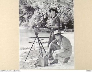 NAGADA, NEW GUINEA. 1944-08-16. VX105754 GUNNER L.W. REA, (1); AND N195534 GUNNER L.M. LOWE, E TROOPS (2) OF THE 22ND BATTERY, 106TH TANK ATTACK REGIMENT, SENDING AND RECEIVING A MORSE MESSAGE ON A ..