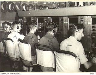 LAE, NEW GUINEA. 1945-02-06. SIGNALLERS OPERATING THE TELEPHONE SWITCHBOARDS AT THE SIGNALS TRANSMITTING CENTRE OF THE 19TH LINES OF COMMUNICATION SIGNALS, HEADQUARTERS, FIRST AUSTRALIAN ARMY. FOR ..