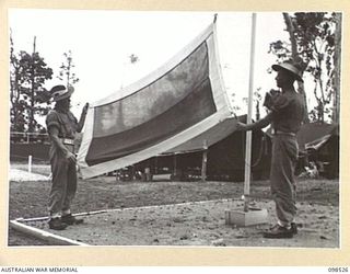 CAPE PUS, NEW GUINEA. 1945-11-03. PRIVATE F.A. WILLIS (1) AND PRIVATE A. PATRONEY (2) MEMBERS OF 2/2 INFANTRY BATTALION, READY TO HOIST THE UNIT FLAG