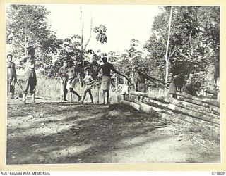 ILOLO, NEW GUINEA, 1944-03-30. QX5849 CORPORAL R. BEVRIDGE (1), AND N37564 CORPORAL W. G. WATERS (2), SUPERVISING THE COLLECTION OF TIMBER FROM A TIMBER POINT BY MEMBERS OF THE NATIVE LABOUR CAMP, ..