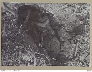 WIRUI MISSION, WEWAK AREA, NEW GUINEA. 1945-05-15. A JAPANESE SOLDIER WHO COMMITTED HARI-KIRI BY HOLDING A HAND GRENADE AGAINST HIS FACE. THE AREA IS NOW OCCUPIED BY 2/4 INFANTRY BATTALION TROOPS